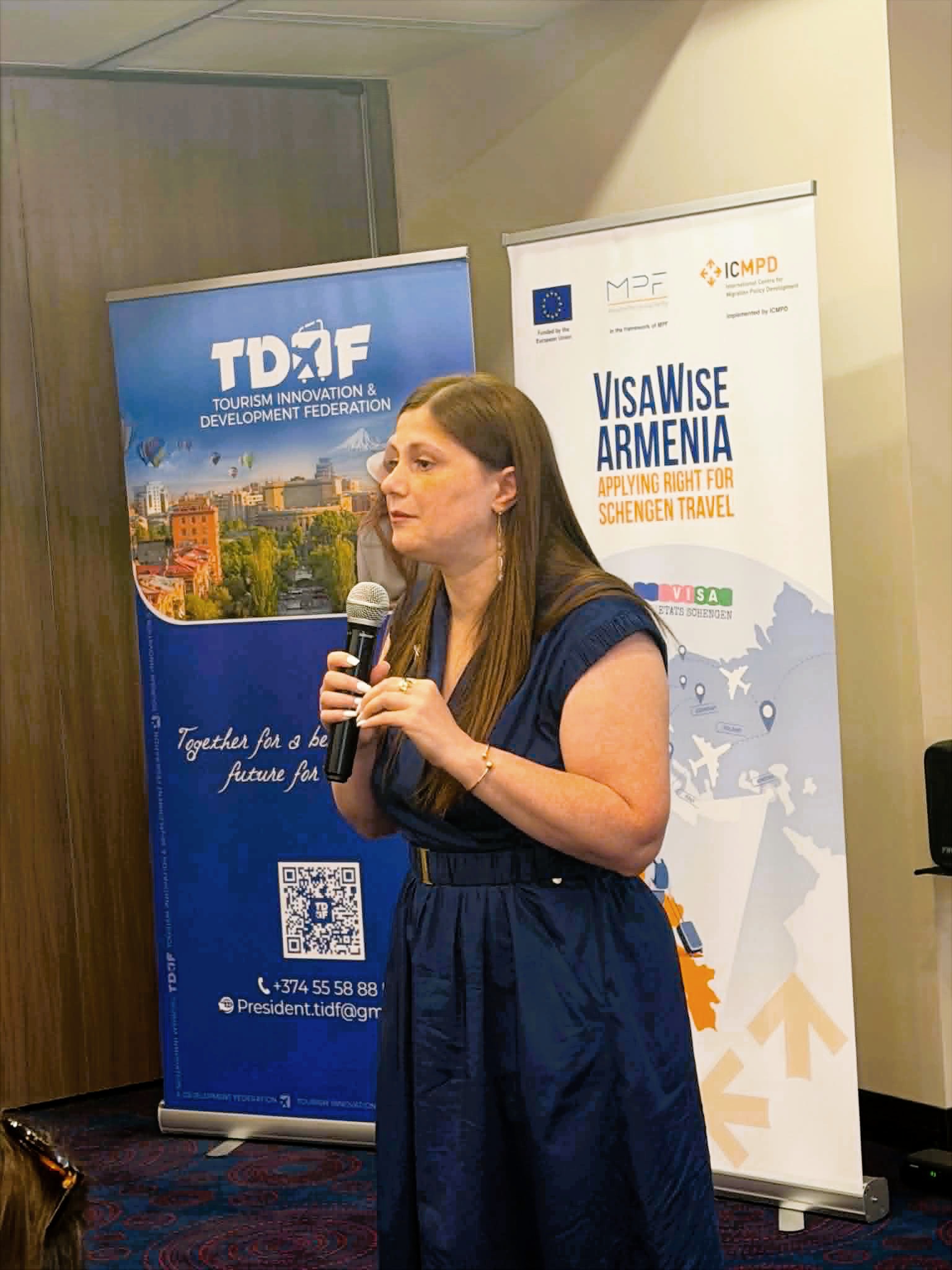 Alina Petrosyan, President of the Tourism Innovation & Development Federation with a microphone during one of the infosessions for the VisaWise Armenia Project